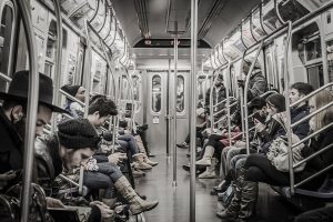 Foto de un vagón del metro de nueva york en el que se ven personas con móvil. Fuente Wikicommon